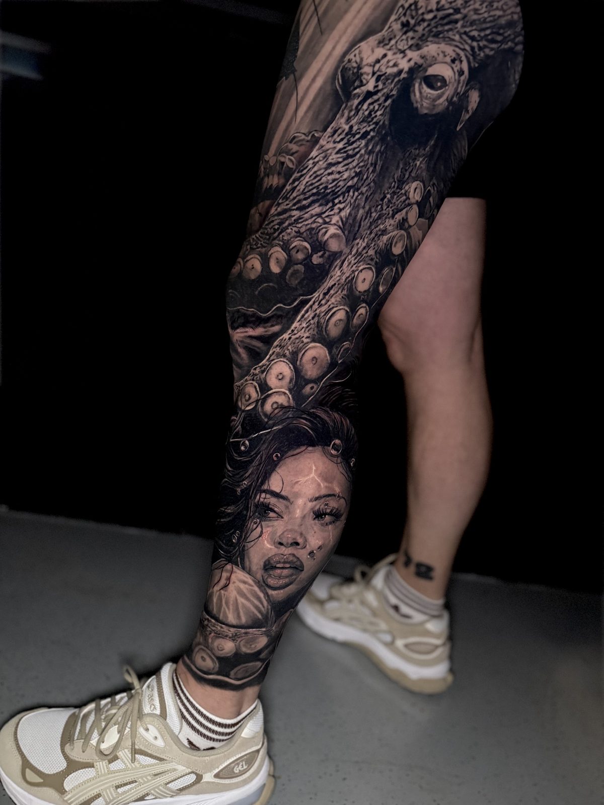 Een heel been in black and grey, met een octopus en een portret