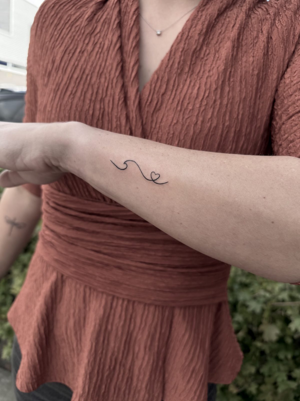 Kleine tattoo van één fijne lijn op de pols